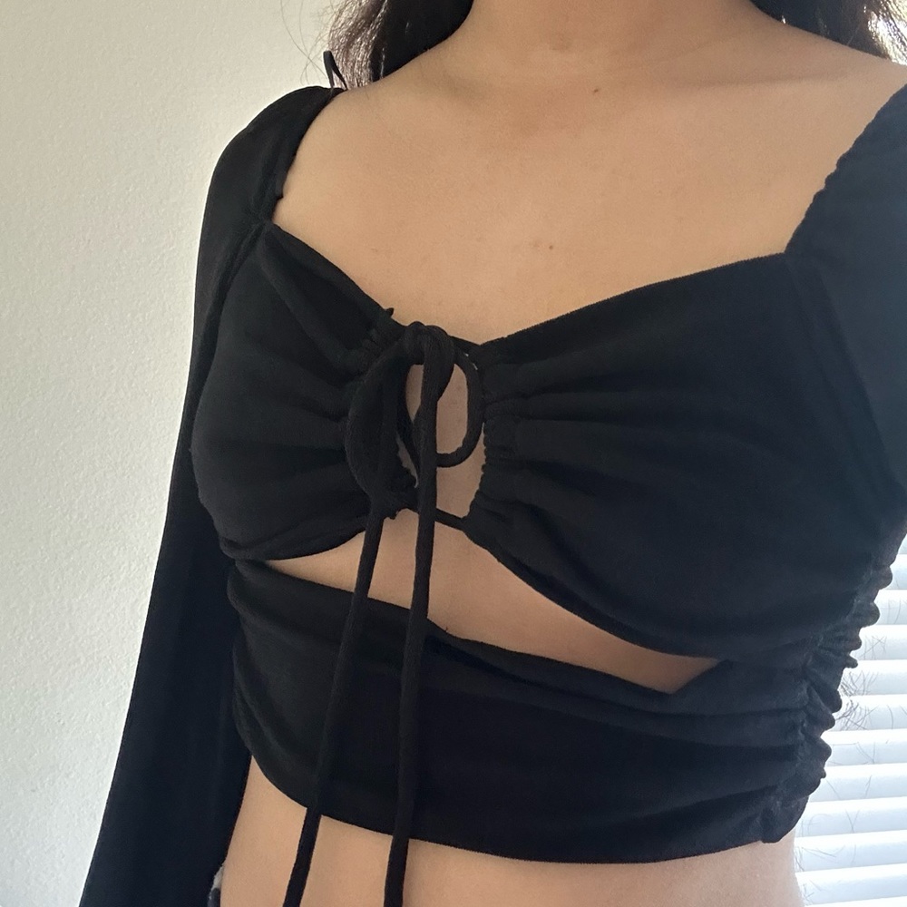 black shimmering peasant top with cutouts and adjustable front tie top